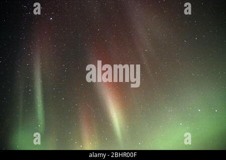 Des stries vertes d'Aurora Borealis ou de Northern Lights apparaissent dans le ciel nocturne au-dessus de la baie James et de la ville de Moosonee, Ontario, Canada. Banque D'Images