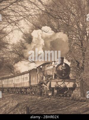 Vue avant de la sépia du train à vapeur britannique vintage (locomotive 7802) qui traverse la campagne rurale du Worcestershire, chemin de fer patrimonial de Severn Valley. Banque D'Images