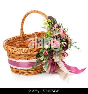 Panier en osier naturel avec fleurs et rubans. Magnifique noeud sur le côté. Isolé Banque D'Images