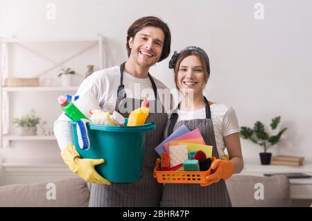 Services de conciergerie. Portrait des nettoyants professionnels avec fournitures ménagères dans les mains Banque D'Images