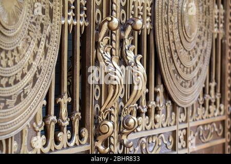 Fragment de portes métalliques forgées et poignées de portes décoratives dans la rue à Danang, au Vietnam, gros plan Banque D'Images