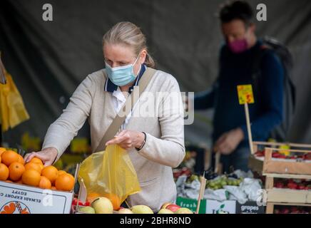 Hambourg, Allemagne. 27 avril 2020. Une femme et un homme portent des masques de bouche à nez lorsqu'ils font des achats dans un magasin de fruits et de légumes. Crédit: Axel Heimken/dpa/Alay Live News Banque D'Images