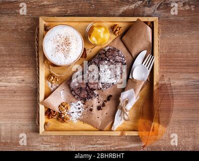 Café à la cannelle, confiture d'orange et biscuits aux pépites de chocolat faits maison. Le dessert se trouve sur du papier kraft et du café dans une tasse de papier. Banque D'Images