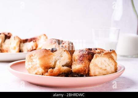 Petits pains à la cannelle servis en assiette sur la table du matin du petit déjeuner, gros plan Banque D'Images