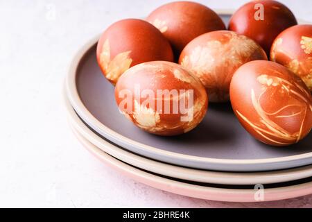 Naturellement teint avec des coquilles d'oignon oeufs de Pâques, des plantes de printemps, concept zéro déchet, vie durable Banque D'Images