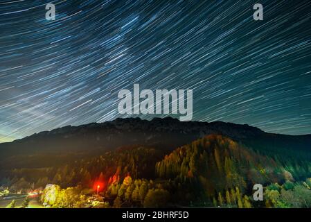 Des pistes étoiles au-dessus de la station balnéaire de Plaiul Foii dans les montagnes de Piatra Craiului de Roumanie Banque D'Images