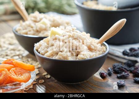 Bols de porridge sain de flocons d'avoine avec abricots secs et raisins secs. Banque D'Images