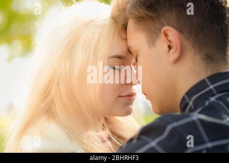 Un homme affectueusement appel regarde la femme, le gars et la fille valent la peine de fermer, touchant des bouts nez. Concept de premier amour d'adolescence et premier baiser. Garçon et Banque D'Images
