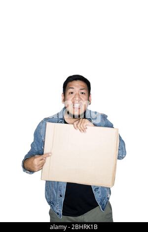 Le travailleur asiatique barbu vêtu de jeans tient et pointe vers le carton en blanc. Le concept de protestation, attention, demande. Place pour Banque D'Images