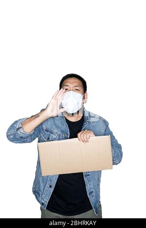 Le travailleur asiatique barbu vêtu d'un Jean avec masque médical tient du carton et crie sur fond blanc. Le concept de protestation, attention, r Banque D'Images