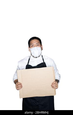 Barbu asiatique homme serveur, chef vêtu d'un tablier noir avec masque médical tient carton en blanc. Le concept de protestation, attention, re Banque D'Images