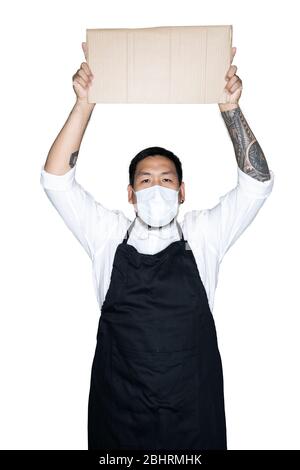 Barbu asiatique homme serveur, chef vêtu d'un tablier noir avec masque médical tient carton en blanc. Le concept de protestation, attention, re Banque D'Images