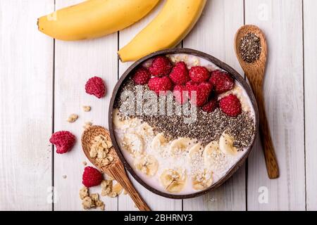 Bol à smoothie aux baies pour le petit déjeuner avec bananes, framboises, mûres et graines de chia. Mise au point douce. Vue de dessus. Concept de nourriture végétalienne saine. Banque D'Images