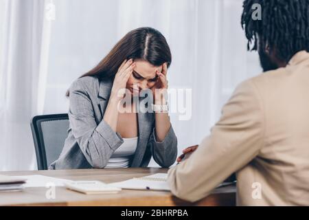 L'accent sélectif du recruteur africain américain avec un employé inquiet et contrarié à l'entrevue d'emploi au bureau Banque D'Images