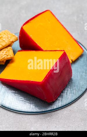 Gros plan de fromage cheddar jaune ciré rouge britannique Banque D'Images