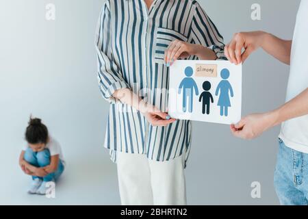 l'accent sélectif des parents tenant du papier avec la famille dessinée et le lettrage aimay près de bouleversé fille africaine américaine sur le blanc Banque D'Images