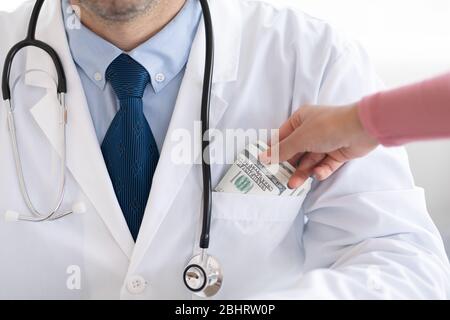 Main féminine mettant de l'argent dans le médecin pocke, closeup Banque D'Images