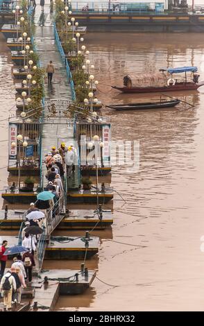 Fengdu, Chine - 8 mai 2010: Les gens marchant sur un pont étroit ponton à leur bateau au terminal de la rivière Yangtze. Eau brune et deux boucles. Banque D'Images