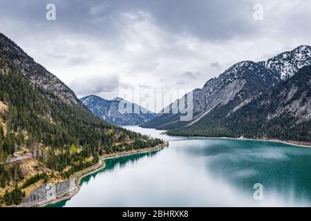 Le paysage aérien improbable du lac, Italie, drone vole bas au-dessus de l'eau d'azure du lac, une plage vide, temps nuageux, littoral, pont Banque D'Images