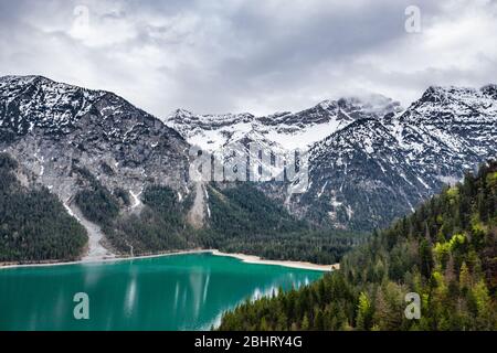 Le paysage aérien improbable du lac, Italie, drone vole bas au-dessus de l'eau d'azure du lac, une plage vide, temps nuageux, littoral, pont Banque D'Images