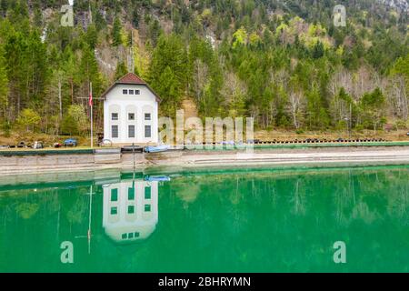 Le paysage aérien improbable du lac, Italie, drone vole bas au-dessus de l'eau d'azure du lac, une plage vide, temps nuageux, littoral, pont Banque D'Images