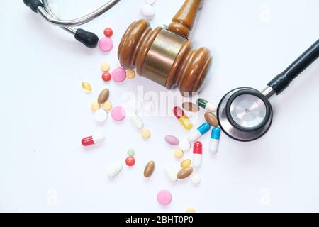 vue de dessus du gavel, du stéthoscope et de la pilule sur le blanc Banque D'Images
