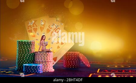 Femme en robe dorée tient de l'argent, assis sur la pile de jetons. Jouer à la table sur fond coloré avec des cartes, contre-jour. Poker, casino Banque D'Images