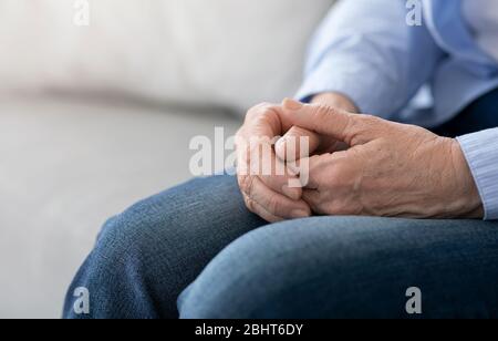 Vieillissement et retraite. Gros plan des mains de la femme âgée assise sur la table Banque D'Images