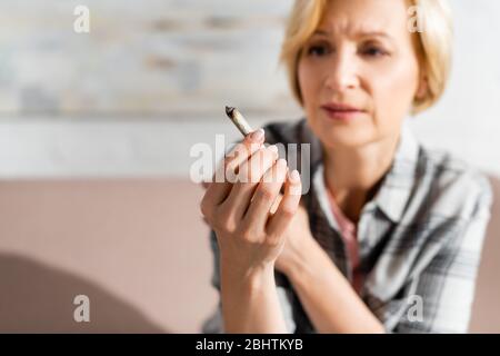 foyer sélectif de la femme mûre tenant conjoint avec la marijuana légale Banque D'Images