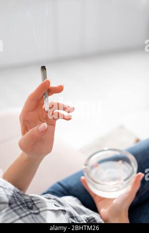 vue rognée d'une femme mûre tenant conjoint avec de la marijuana légale et du cendrier Banque D'Images