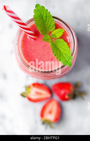 Vue en hauteur d'un smoothie aux fraises avec garniture de baumes au citron sur une surface marbrée Banque D'Images