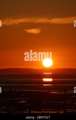 Morecambe Lancashire, Royaume-Uni. 27 avril 2020. Sun descend derrière South Lakes Peninsula Credir crédit: Photographier North/Alay Live News Banque D'Images