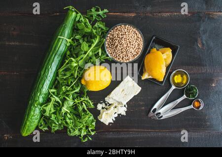 Salade de limonie à l'arugula avec couscous, concombres et feta Ingrédients: Arugula, feta, couscous de perles de blé entier et autres ingrédients de salade Banque D'Images