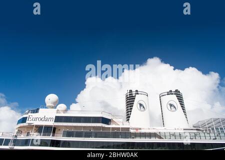 Miami, États-Unis - 31 décembre 2015 : ponts supérieurs et entonnoirs doubles d'Eurodam. Façade du bateau de croisière sur ciel bleu nuageux. Rangées de fenêtres et de balcons. Transport maritime. Aventure et découverte. Banque D'Images