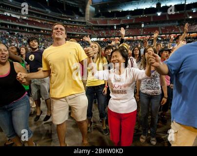 Houston, Texas États-Unis, 6 août 2011: Les membres du public réagissent avec enthousiasme aux prières et à la musique à la réponse, un « appel à la prière pour une nation en crise » qui a attiré plus de 30 000 fidèles à entendre des prières, de la musique gospel et des orateurs évangéliques au stade reliant. ©Marjorie Kamys Cotera/Daemmrich Photographie Banque D'Images