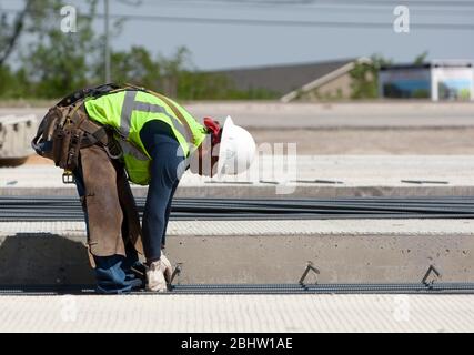 Austin Texas États-Unis, 6 avril 2011 : le travailleur sur le chantier de construction d'autoroute porte une ceinture à outils, un gilet de sécurité réfléchissant, des gants de travail et un casque de sécurité. ©Marjorie Kamys Cotera/Daemmrich Photographie Banque D'Images