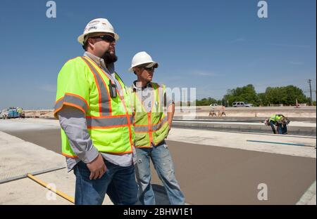 Austin Texas Etats-Unis, 6 avril 2011 : le superviseur de la construction surveille l'équipage travaillant sur une autoroute en béton. ©Marjorie Kamys Cotera/Daemmrich Photographie Banque D'Images