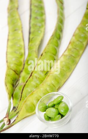 Parkia spéciosa ( pétai, haricot amer, haricot à grappe torsadée, stinker ou grain de stink) sur table en bois blanc Banque D'Images