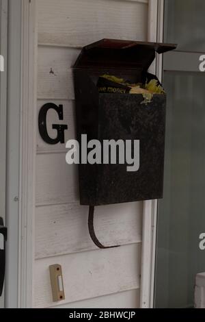 Newport News, va/USA-16 mars 2020: Vieux courrier laissé dans une boîte aux lettres abandonnée dans un quartier de maisons de ville. Banque D'Images