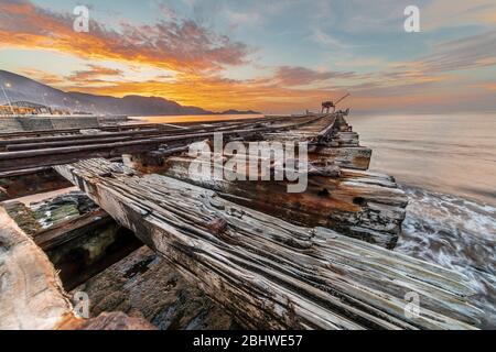 Ancien et historique quai de saltpeter à Taltal pendant le coucher du soleil avec des tons orange sur la structure rugueuse de chemin de fer Banque D'Images