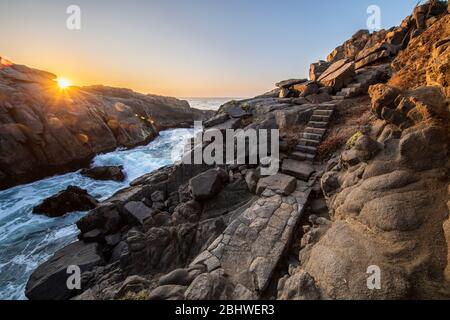 Un sentier magnifique et idyllique entre les rochers de granit en faisant un paysage fantastique d'un autre âge. Un pavé de pierre a coupé les falaises de la mer Banque D'Images