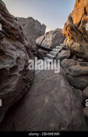 Un sentier magnifique et idyllique entre les rochers de granit en faisant un paysage fantastique d'un autre âge. Un pavé de pierre a coupé les falaises de la mer Banque D'Images