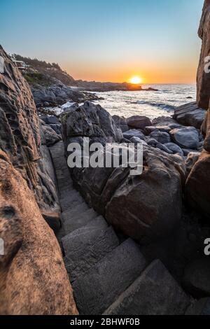 Un sentier magnifique et idyllique entre les rochers de granit en faisant un paysage fantastique d'un autre âge. Un pavé de pierre a coupé les falaises de la mer Banque D'Images