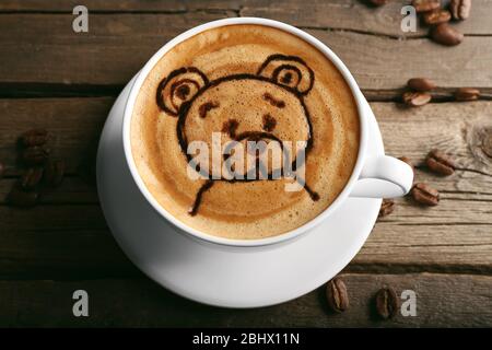 Tasse de café d'art Latte avec des grains sur fond en bois Banque D'Images
