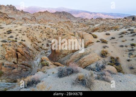 Le sentier de l'Arche de Mobius serpente à travers des formations rocheuses dans les collines d'Alabama près de Lone Pine, Californie, États-Unis Banque D'Images