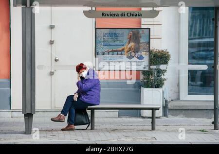 Naples, Italie. 26 avril 2020. Une femme portant un masque facial comme mesure préventive attendant un bus pendant le verrouillage.A la suite de la pandémie de covid19 qui a fortement frappé l'Italie, le premier ministre, Giuseppe Conte a ordonné de fortes restrictions pour la quarantaine afin de minimiser la propagation du virus corona. Crédit: SOPA Images Limited/Alay Live News Banque D'Images