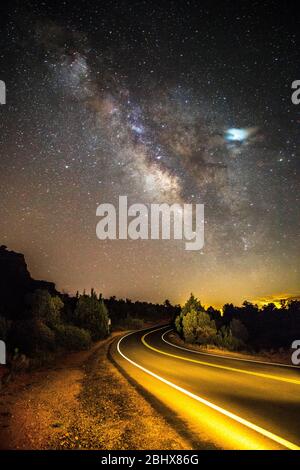 Conduite sur une route courbe sous la voie laiteuse et les étoiles Banque D'Images