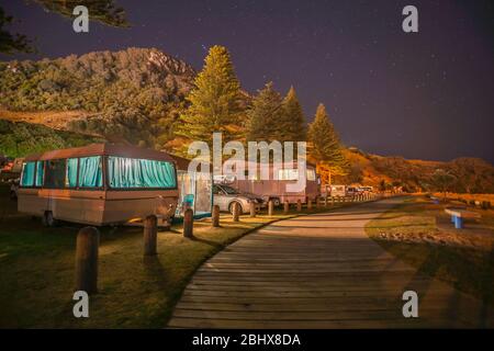 Caravanes et mobile homes de vacanciers sous stary Sky le long d'une passerelle en bois jusqu'à la base du Mont Maunganui Nouvelle-Zélande. Banque D'Images