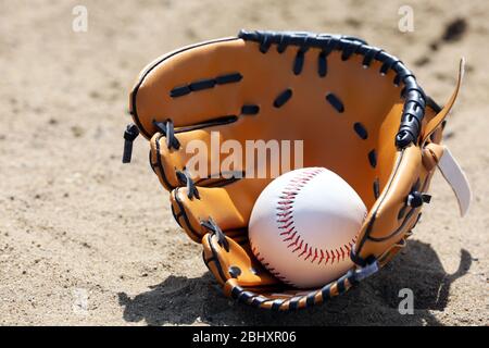 Balle de base-ball et gant sur sable Banque D'Images