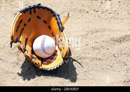 Balle de base-ball et gant sur sable Banque D'Images